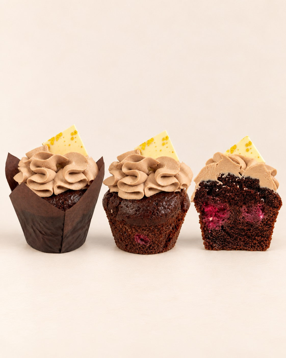 Chocolate - Tahini Muffin by Batida - two muffins, with and without a paper case, and a half with a raspberry inside