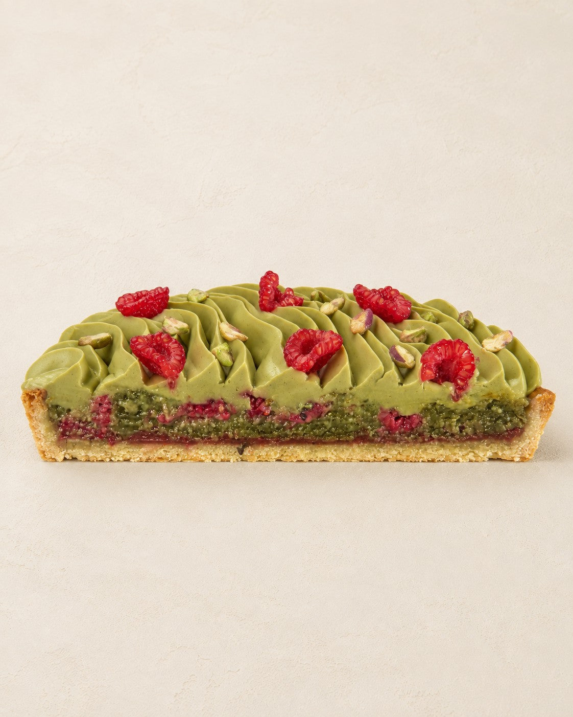 Pistazien-Frangipane-Tarte mit Himbeeren von Batida - halbe Tarte von der Seite, Querschnitt der Frangipane mit Himbeeren