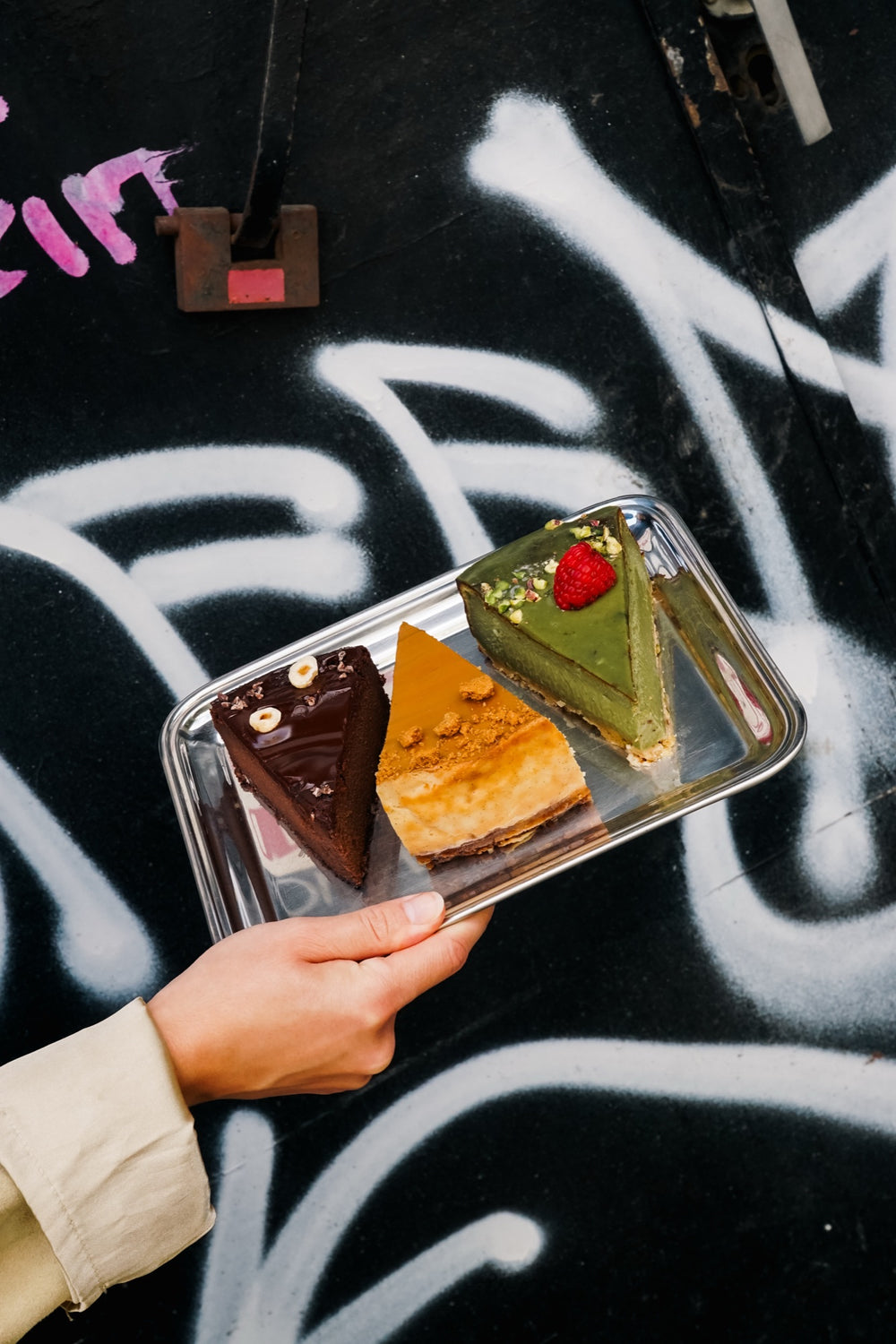 Ein Tablett mit Batida-Käsekuchen vor einer Graffiti-Wand