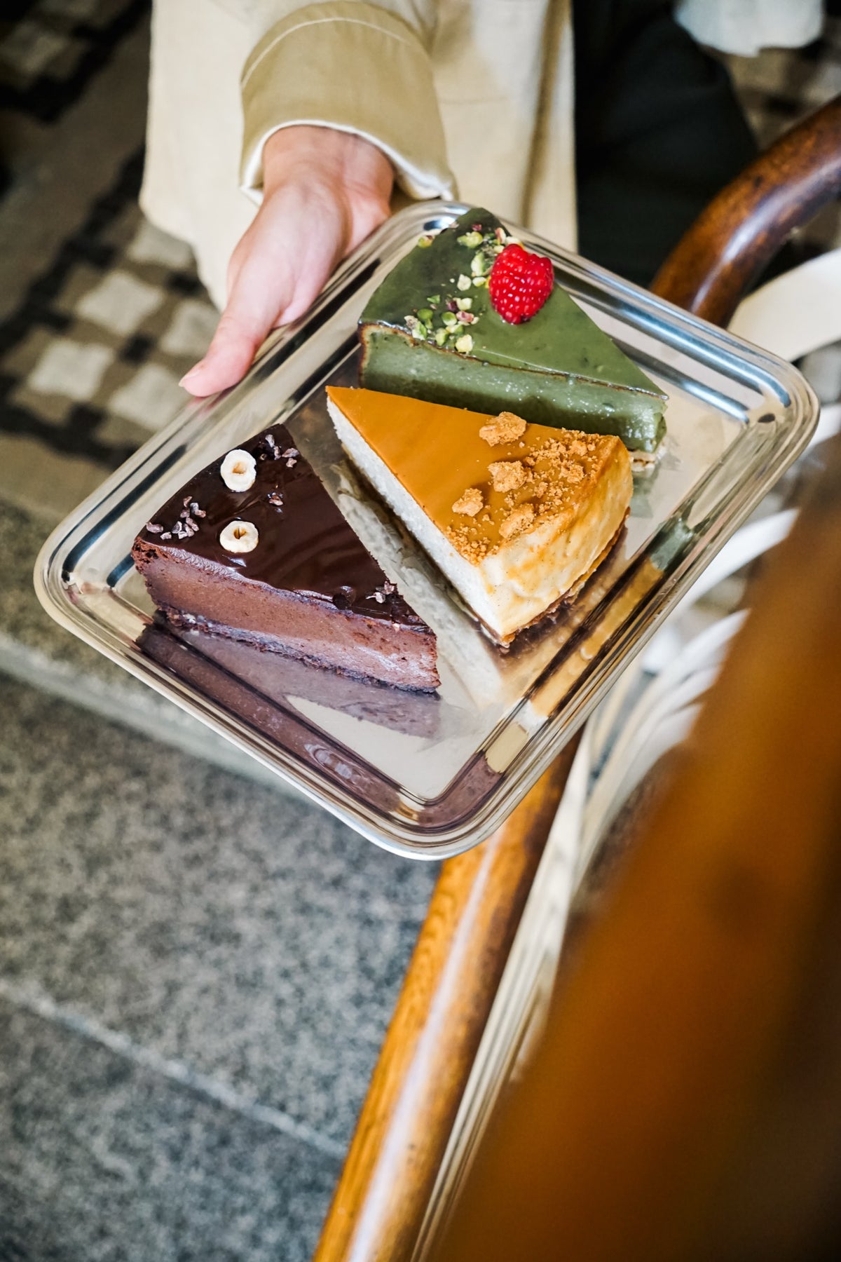 Batida Käsekuchen Matcha, Lotus und Schokolade auf einem Tablett neben einem Caféstuhl