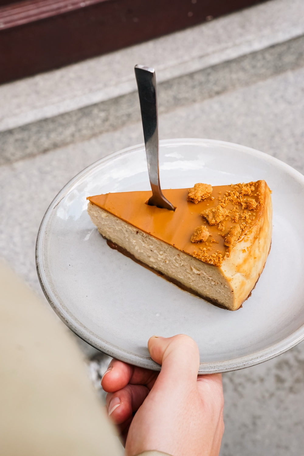 Lotus-Käsekuchen Batida auf einem von einer Hand gehaltenen Teller