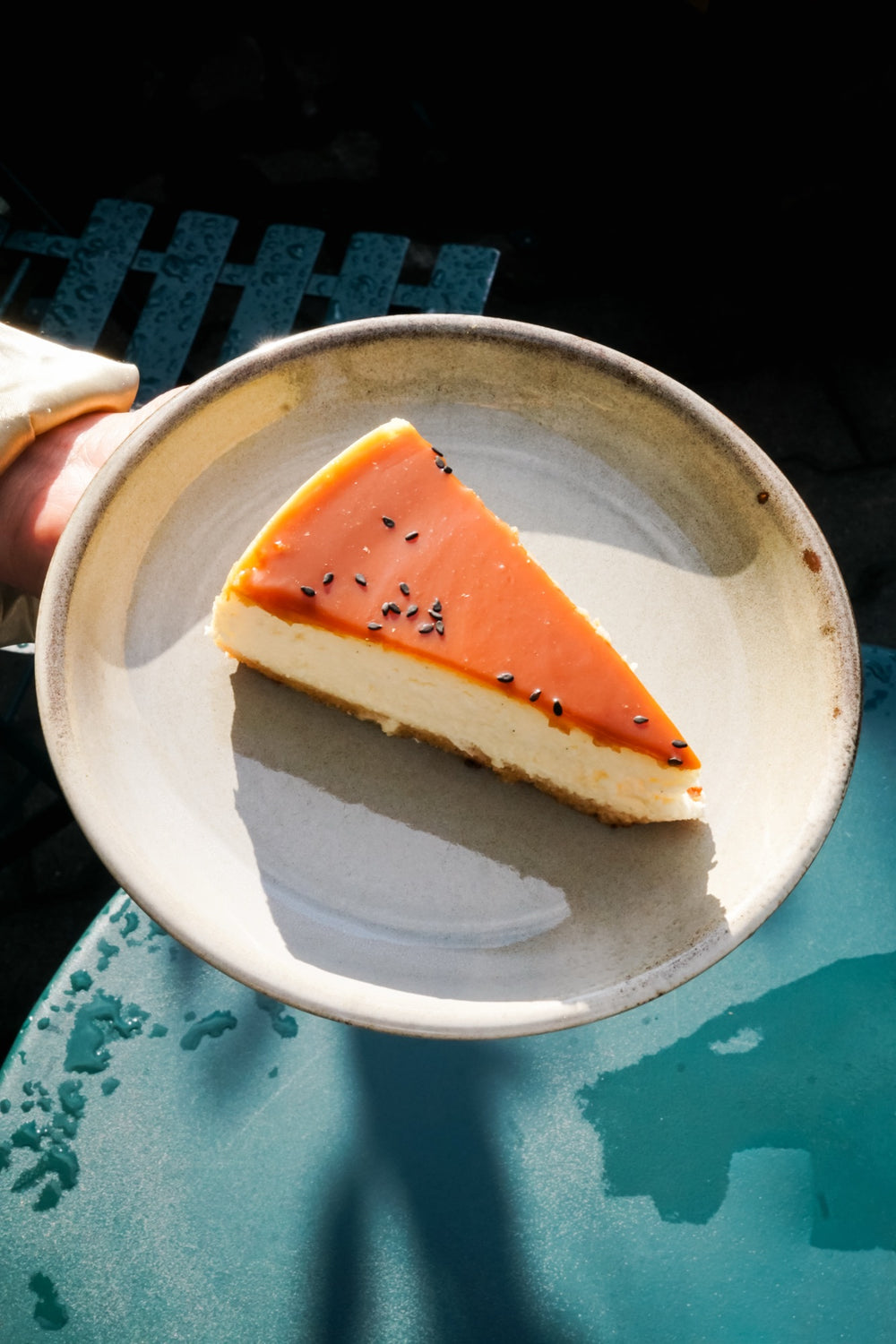 Ein Stück baskischer Batida-Käsekuchen mit Karamellüberzug und schwarzem Sesam auf einem Teller