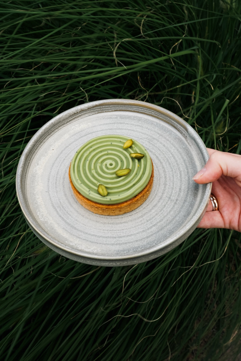 Matcha-Törtchen Batida auf einem Teller vor einem Grashintergrund