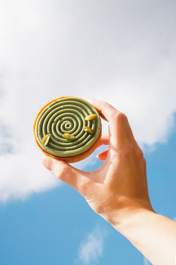 Eine Batida-Tartelette in der Hand vor dem Himmel