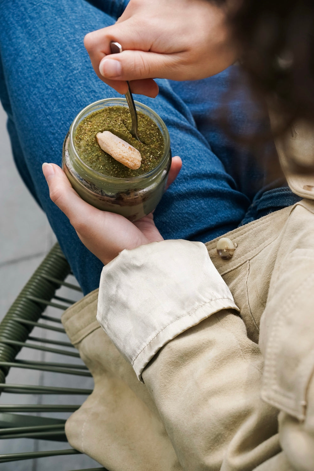 Matcha-Batida-Dessert im Glas mit Biskuit, mit einem Teelöffel gegessen