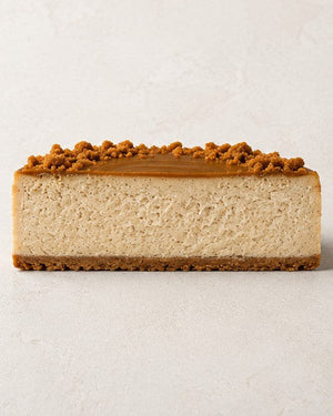 Lotus-Käsekuchen von Batida - halber Käsekuchen von der Seite, Querschnitt mit Lotus-Creme und Keksen obenauf