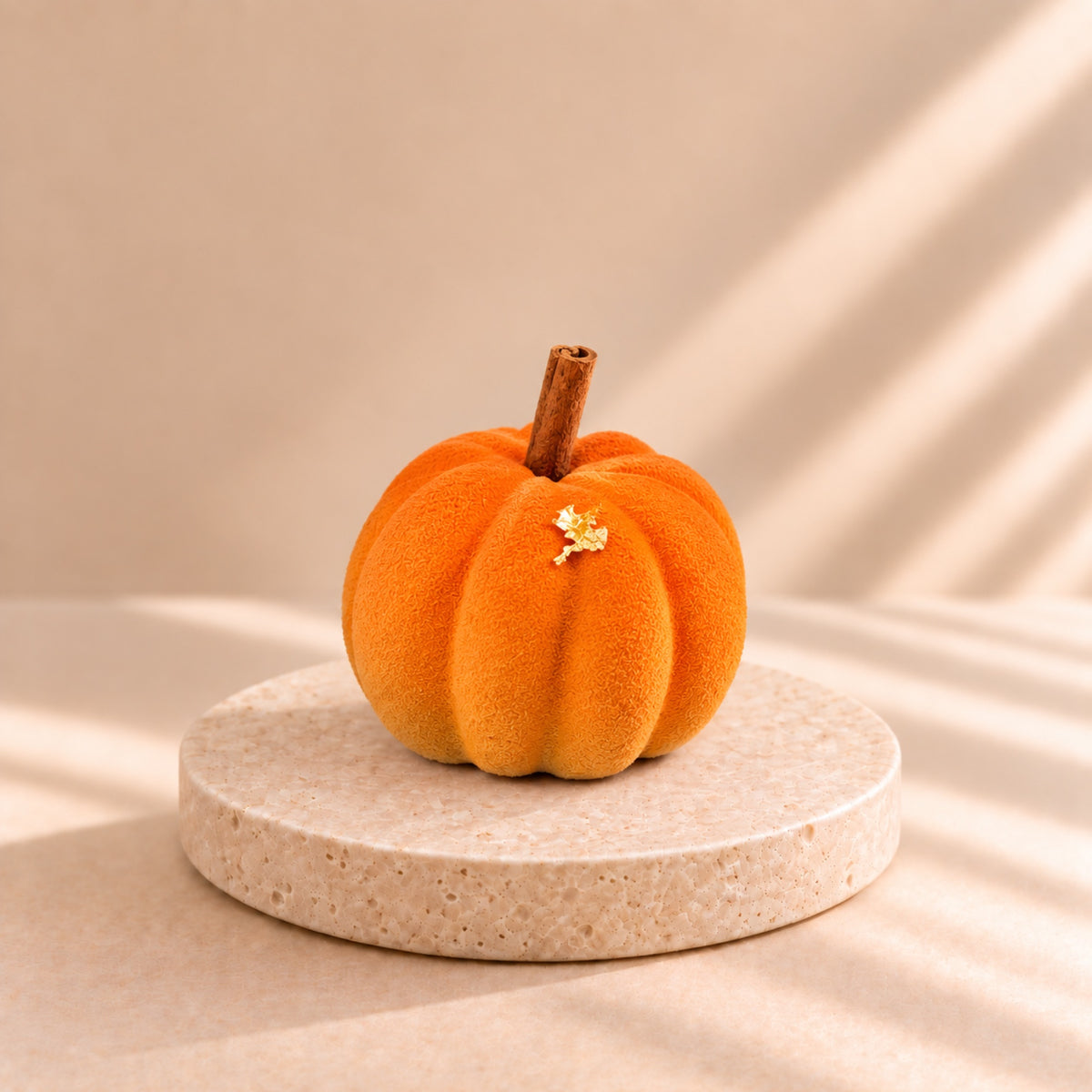 Pumpkin Latte - orange pumpkin-shaped individual dessert on a stone stand